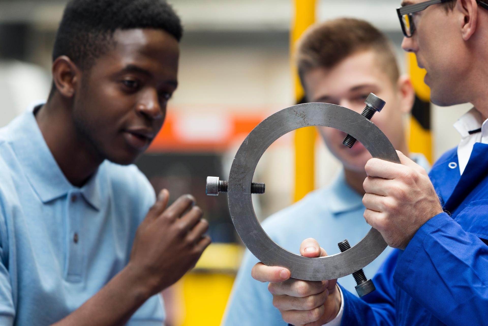Tuteur avec 2 apprentis et pièce métallique