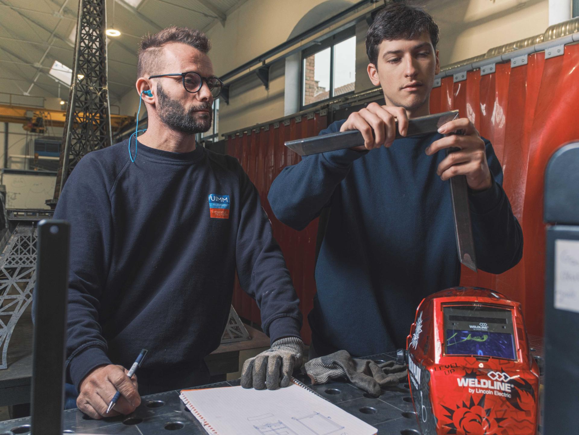 Formateurs enseigne les techniques de chaudronnerie à un futur apprenti