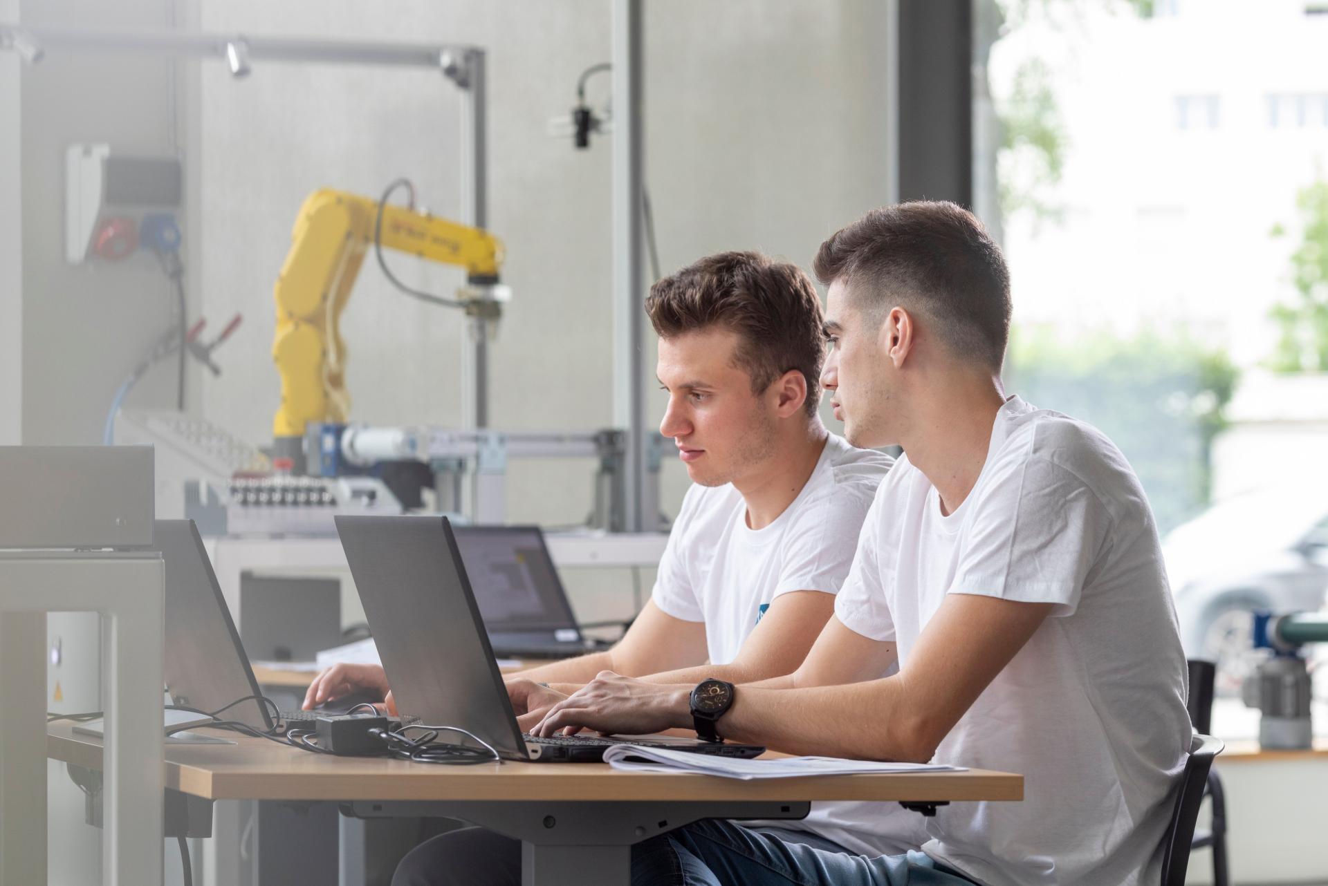2 apprentis en salle robotique devant leurs ordinateurs