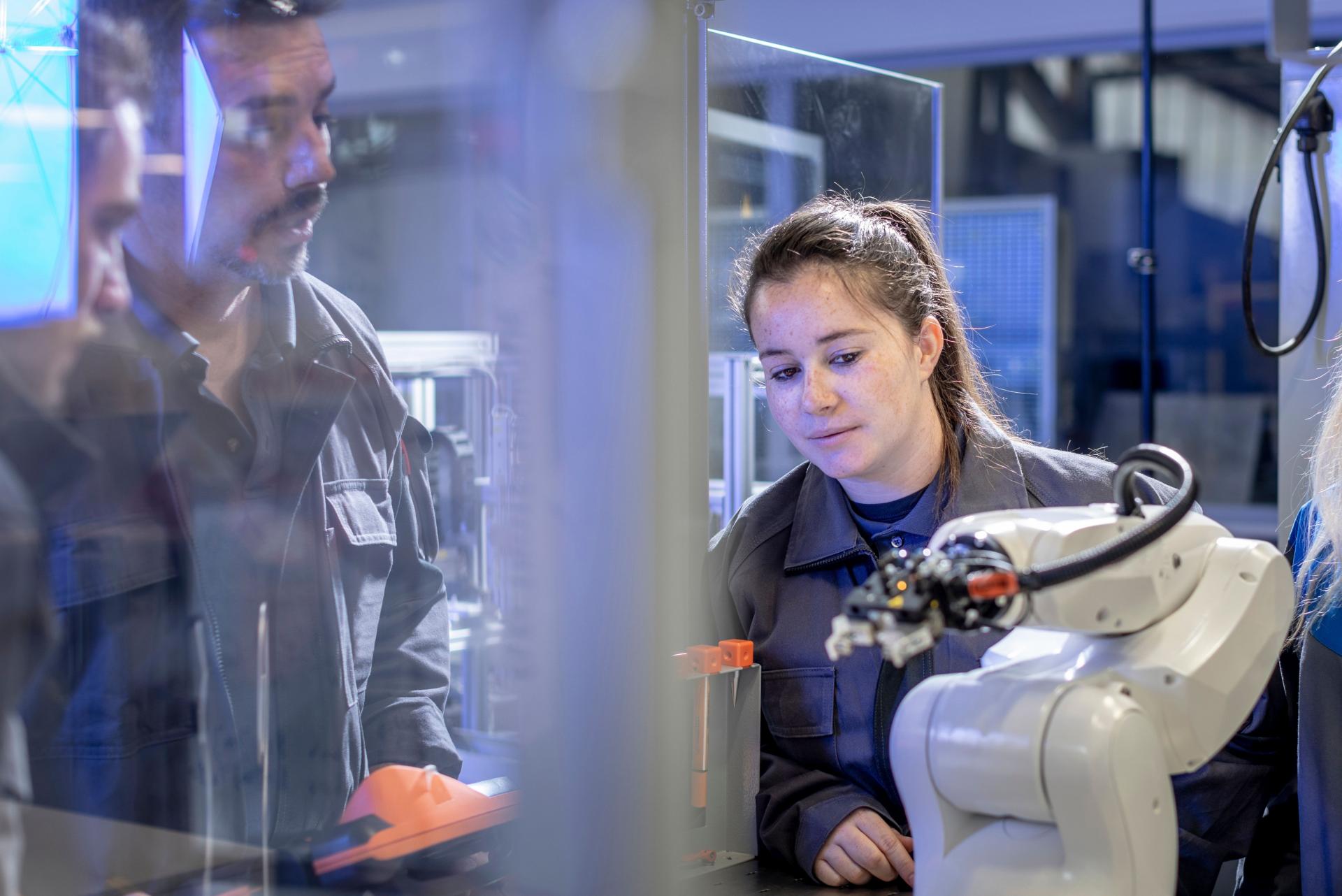 jeune apprentis avec tuteur et bras robot