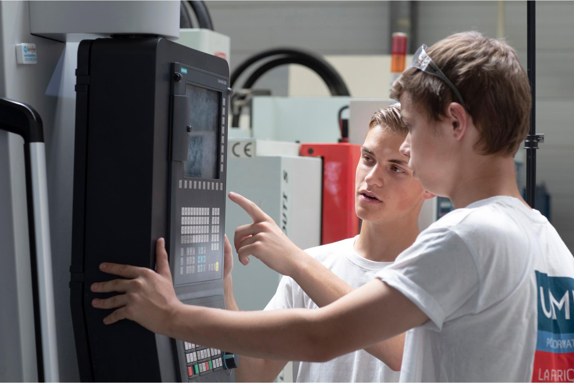 2 apprentis sur machine à commandes numériques