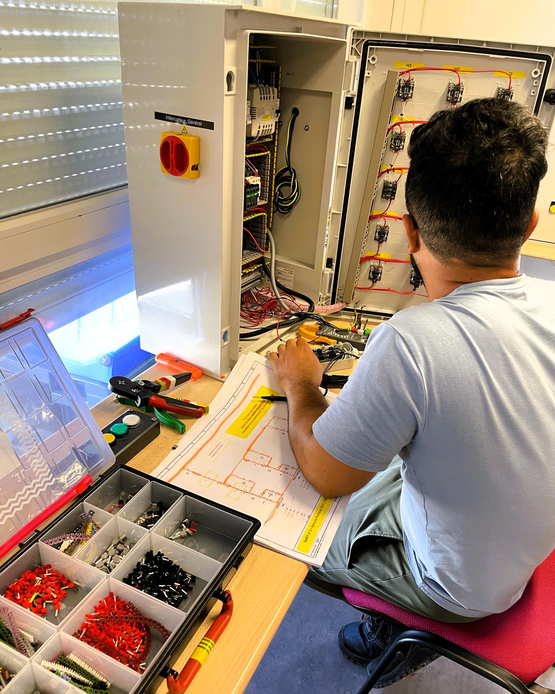Technicien manipule armoire électrique