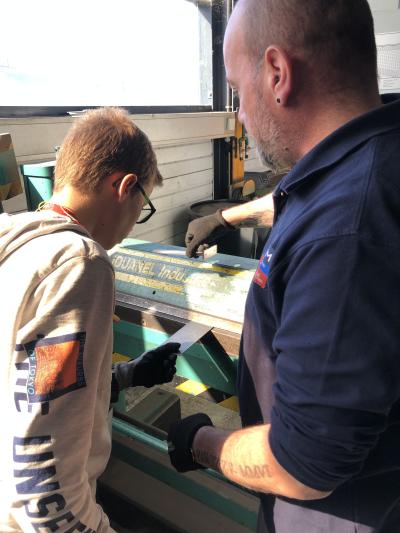 Formateur avec un jeune en atelier découverte métier de la chaudronnerie