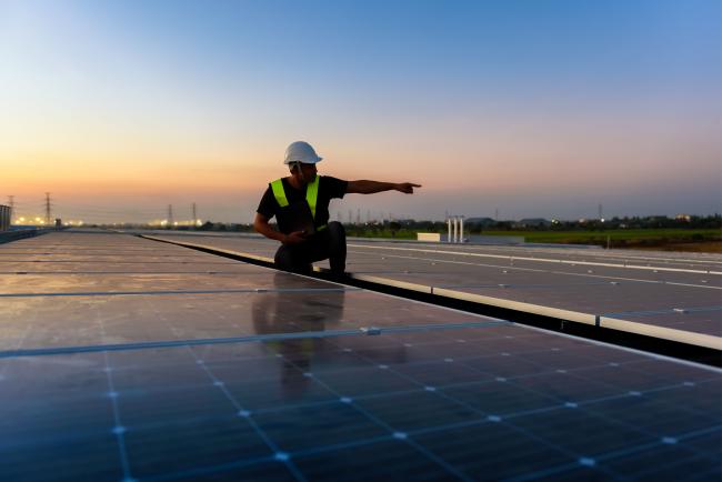 homme bras tendu toit photovoltaïque