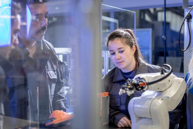jeune apprentis avec tuteur et bras robot