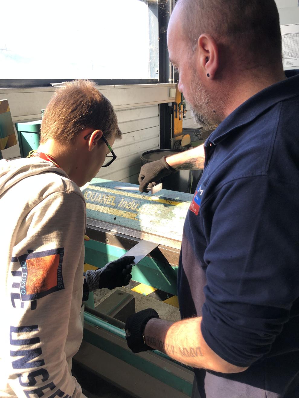 Formateur avec un jeune en atelier découverte métier de la chaudronnerie